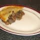 Pastry is laid on top of steak, liver and kidney pie filling.