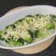 Cheese is grated over drained broccoli