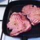 Gammon steaks are turned on the griddle pan