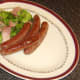 Sausages are plated with sauteed cabbage and bacon