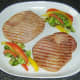 Sauteed cabbage and peppers are plated with gammon steaks