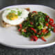 Pork chop, fried egg and sauteed cabbage combination are plated