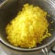 Draining turmeric spiced rice