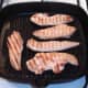 Chicken strips are turned in griddle pan
