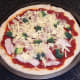 Cheddar cheese is scattered over pizza
