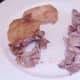 Meat is plucked from roast chicken thighs