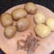 Cooked and cooled potatoes are carefully peeled for pan roasting