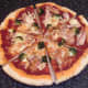 Pizza is transferred to a chopping board and cut for service