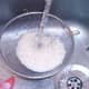 Rice is washed under running cold water