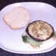 Cheese stuffed mushroom is laid on salad bed