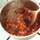 Chickpeas and chopped coriander are added to curry sauce