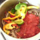 Bell peppers and tomatoes added to spiced beef