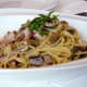 Pasta with bacon, shavings of Pecorino-Romano cheese, and basil