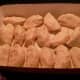 Apple dumplings wrapped in refrigerated crescent roll dough, prior to baking.