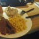 a dinner plate with potatoes and gravy, corn and a sweet Hawaiian roll