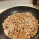 Chopped walnuts and sugar in the frying pan.