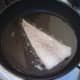 Cod is laid skin side down in frying pan