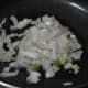 Step three: Saute spring onion whites, garlic, and green chili.