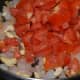 Step four: Add chopped tomato. Cook over high flame. 