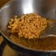 Step six: Remove them on a paper towel. Add fried peanuts, curry leaves, and a mix of chili powder, salt, and sugar.
