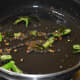 Step two: The tempering made by sauteing mustard seeds, white lentil, green chilies, hing, and curry leaves.