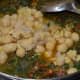 Step seven: Add cooked chickpeas. Mix well. Cook for a few minutes on a low fire.