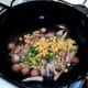 Peas and sweetcorn are added to wok