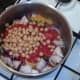 Tomatoes and chickpeas are added to pot