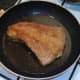 Pork fillet is turned in frying pan
