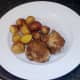 Plated chicken thighs and roast potatoes
