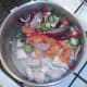 Prepared vegetables are added to sealed chicken