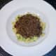 Spicy beef is spooned on to turmeric mash