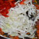Step five: Throw in shredded cabbage and chopped red capsicum. Add salt and mix. Keep the heat medium-high.
