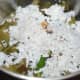 Step three: Add the cooked eggplants into the mixer grinder. Add green chilies, grated coconut, asafoetida (hing) powder, mustard seeds, and salt. Grind to get a near-smooth paste.