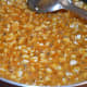 Step eight: Once you get the proper consistency, add peanuts into the jaggery syrup. Boil together for 1 minute.