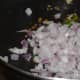 Step three: Add chopped onions and chopped green chilies. Saute till onions become transparent.