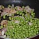 Step two: Add fresh peas. Continue stir-cooking.