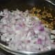Step two: Heat oil in a deep-bottomed pan. Add cumin seeds. Let them sizzle. Add chopped onions. Saute till they turn transparent and pinkish.
