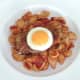 Fried egg circle is laid on pork steak