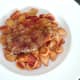 Paprika spiced pork steak is laid on conchiglie pasta