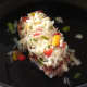 Spicy cheese and peppers mix is scattered over pork steak