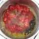 Canned tomatoes and seasonings are added to garlic and oil