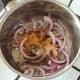 Sliced onion and spices are added to saucepan