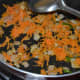 Step 4: Add grated carrots. Saute for a minute.