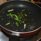Heat oil in a wok or deep-bottomed pan and throw in the mustard seeds. Saut&eacute; until they crackle. Add the slit green chilies, hing powder, and curry leaves. Saut&eacute; for 30 seconds.