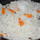 Step three: Add turmeric powder. Mix well. Throw in cooked rice and diced carrots mix. Add a little salt and sugar.