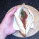 Curry sauce is spooned in to pitta pocket