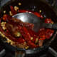 Step two: Fry white lentils, coriander seeds, and dry red chilies in some oil.