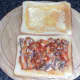 Sardines in tomato sauce are spread on toast