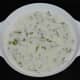 Add the wheat semolina, finely chopped ginger, finely chopped coriander leaves, green chilies, and chopped coconut. Mix well and set aside for ten minutes.
